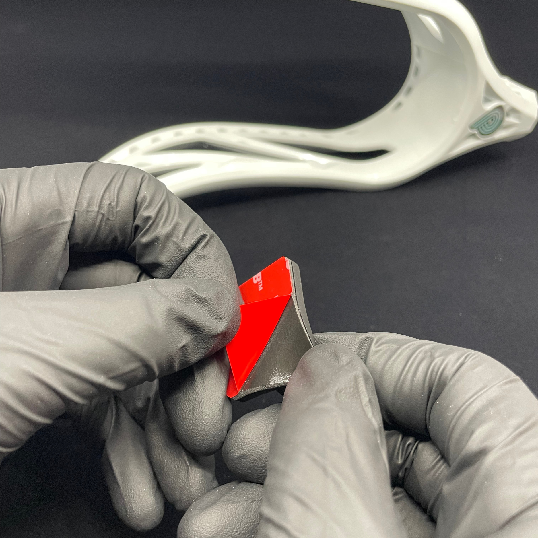 Lacrosse player putting new ball stop on their lacrosse head.